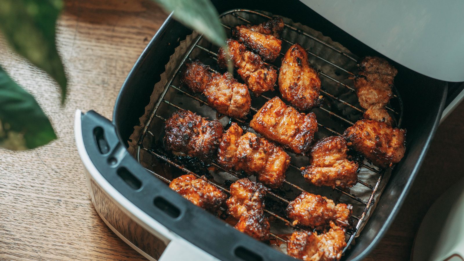 Large air fryer sitting on a kitchen counter with fresh vegetables nearby