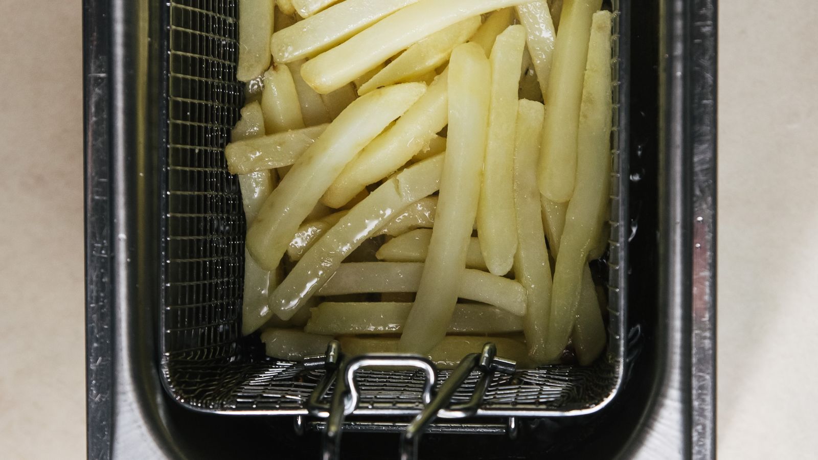 Hand adjusting the digital control panel of a large capacity air fryer