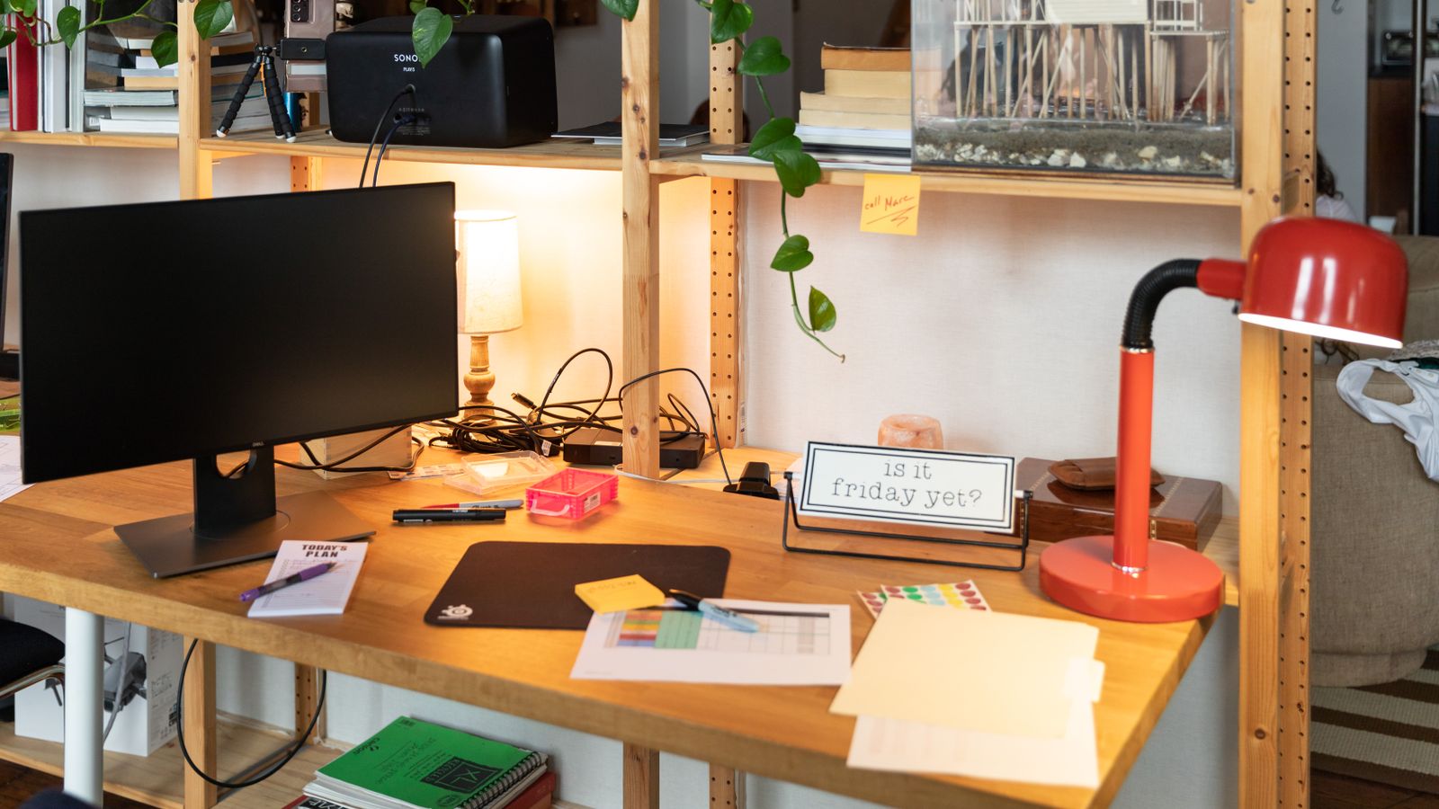 Organized home office desk setup with shelf, monitor, and cable management underneath