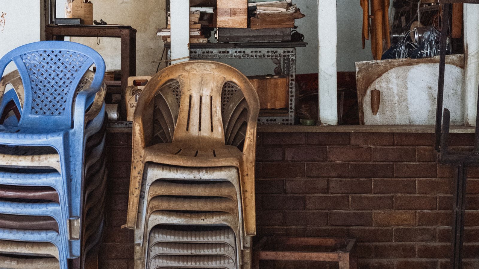 Neatly organized stack of chairs against a wall in an office storage room