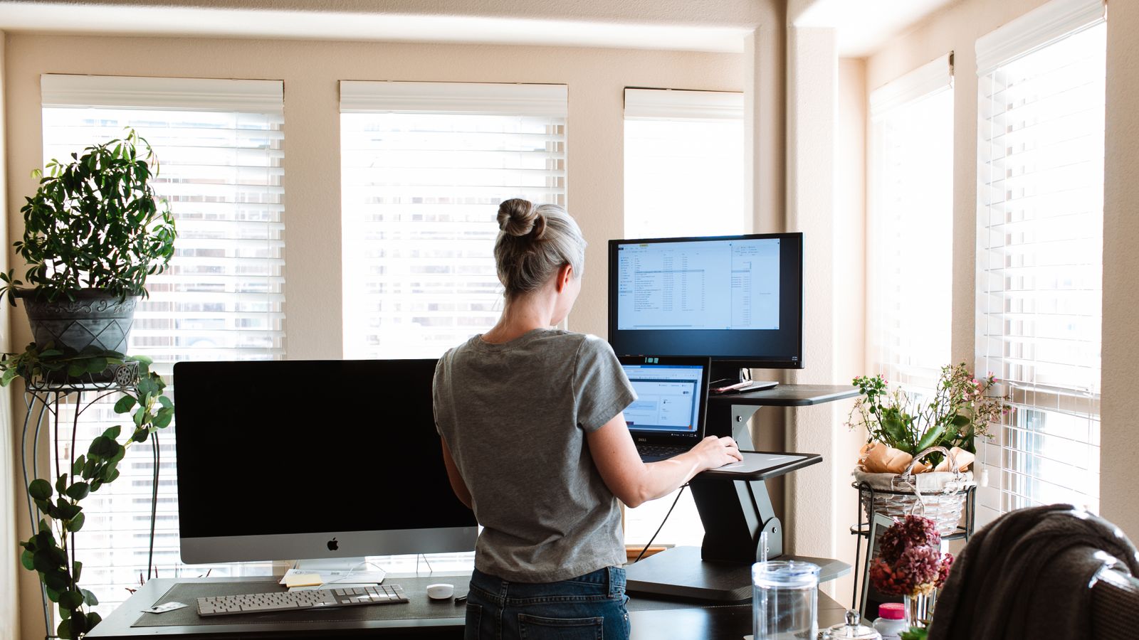 Small home office with a compact standing desk against a narrow wall