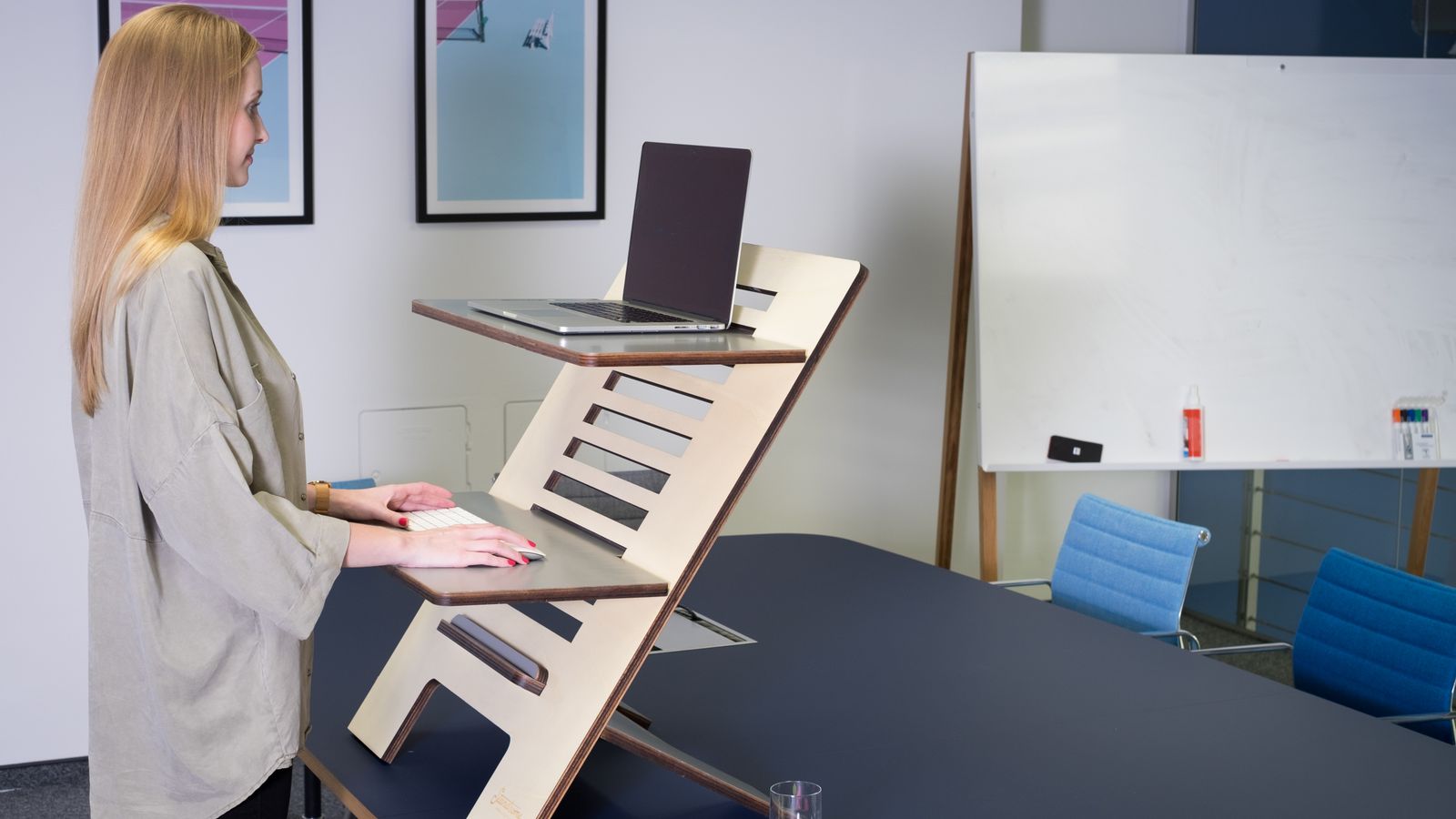 Tape measure laid across a compact standing desk to compare desktop dimensions