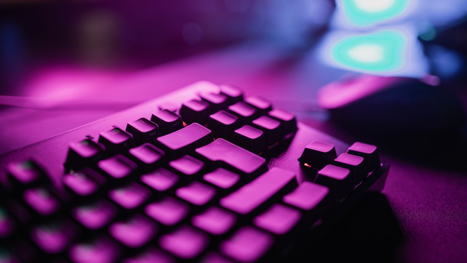 Large hand resting on a low profile keyboard next to an ergonomic mouse on a desk