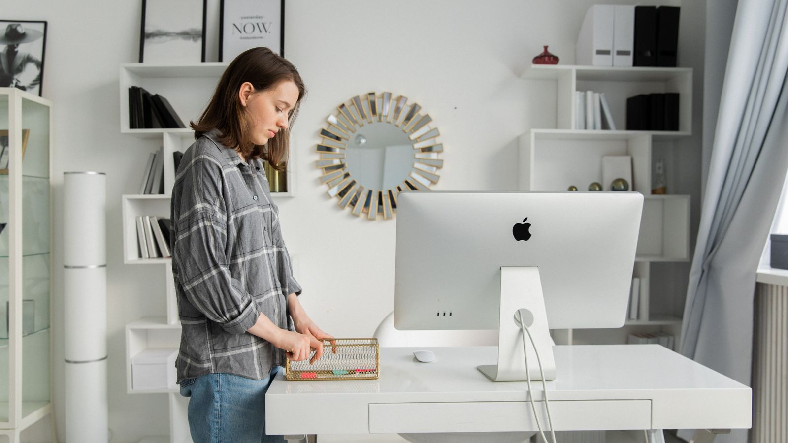 Person adjusting the height of an affordable standing desk with a manual crank