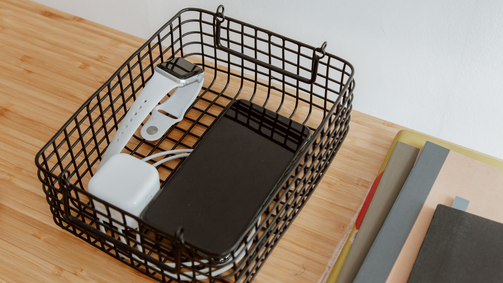 Charging dock with multiple devices connected and cables tucked along a desk edge