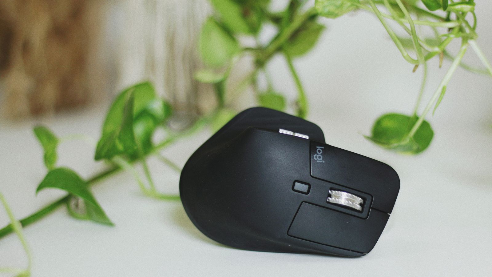 Compact ergonomic mouse sized for a small hand resting on a desk mat