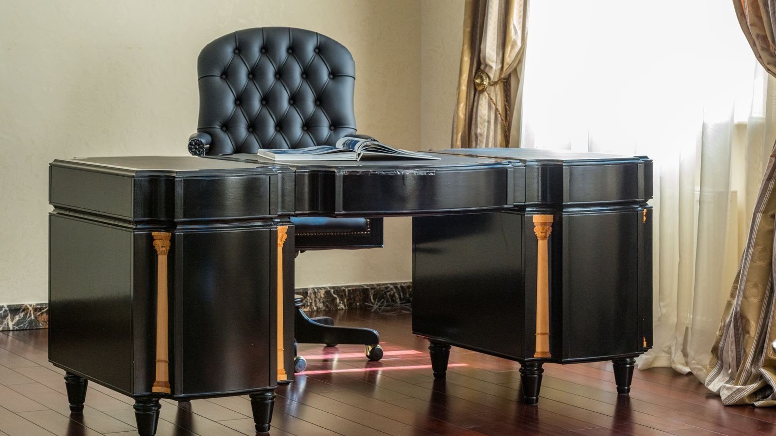 Executive desk with wood finish and leather chair in a home office