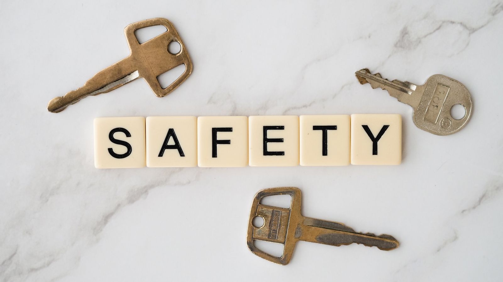 Keys and a padlock arranged on a table symbolizing home safety and lock maintenance