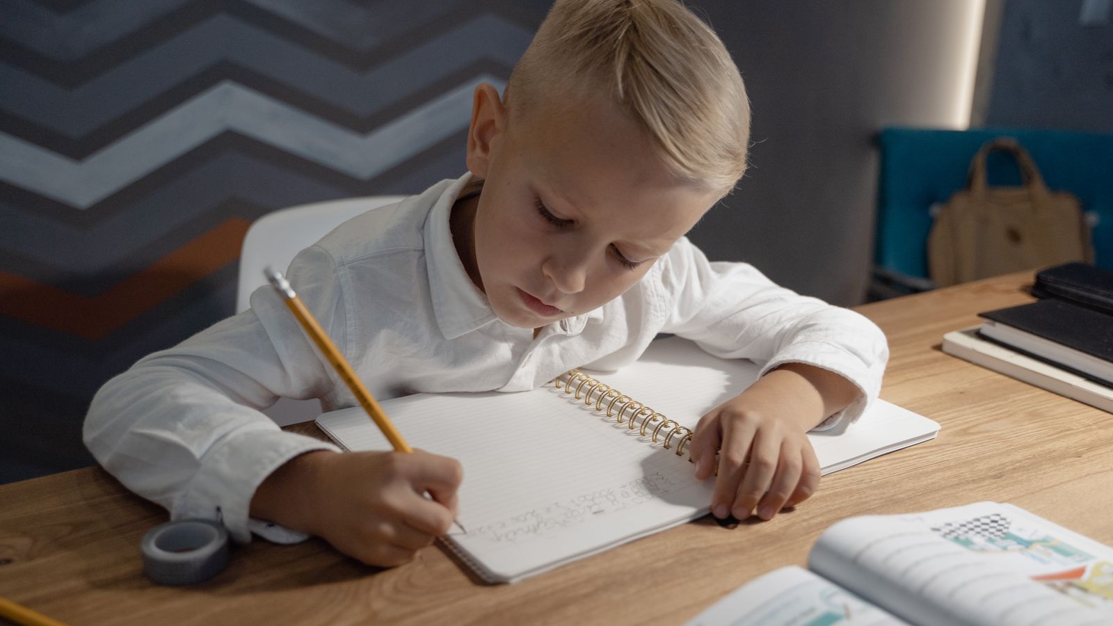 Child working at a homework desk with books and supplies organized