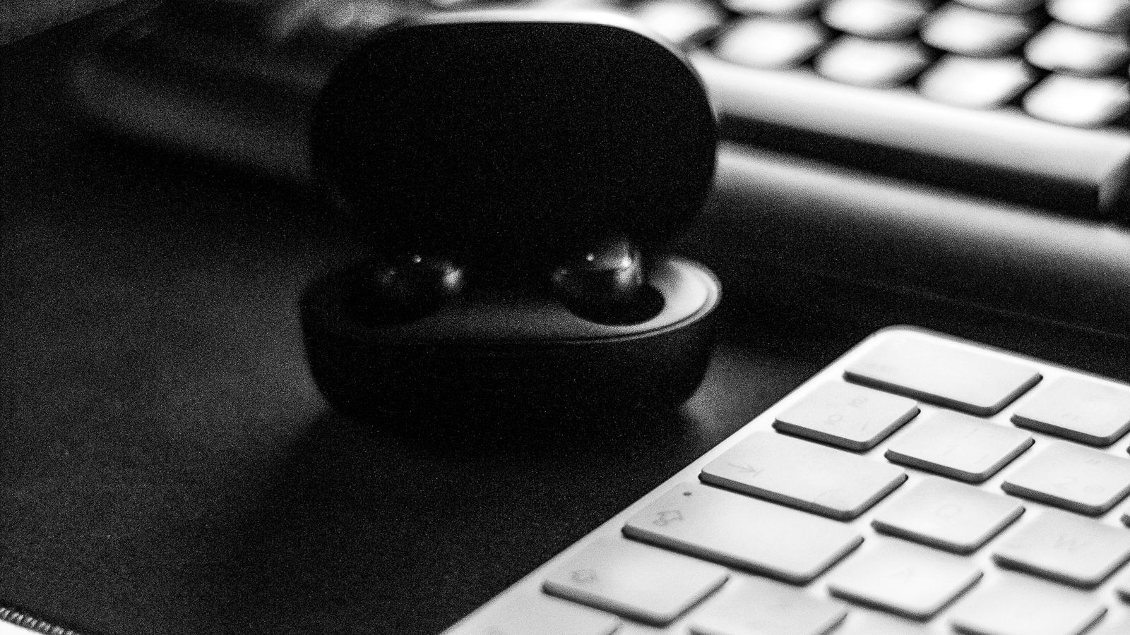 Sliding keyboard drawer mounted under an office desk with a wireless keyboard and mouse