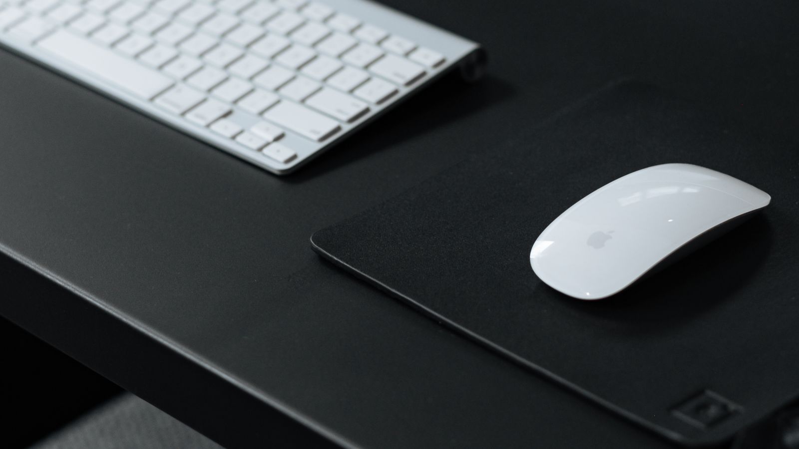 Close-up of a wireless keyboard receiver plugged into a laptop on a tidy desk