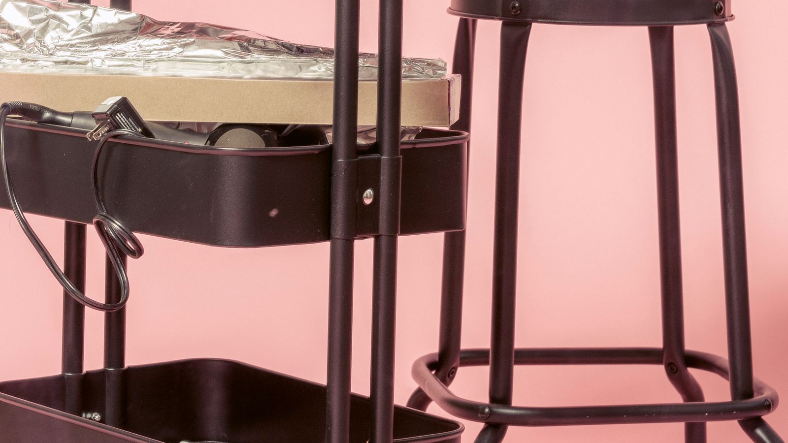 Person leaning on a perch stool while working at a standing desk