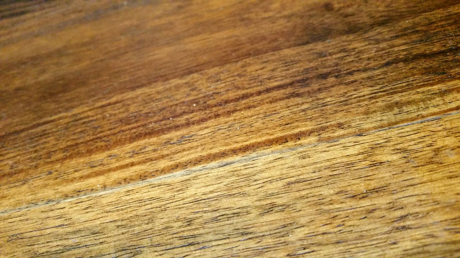 Close-up of a solid wood desk surface showing natural grain and warm finish