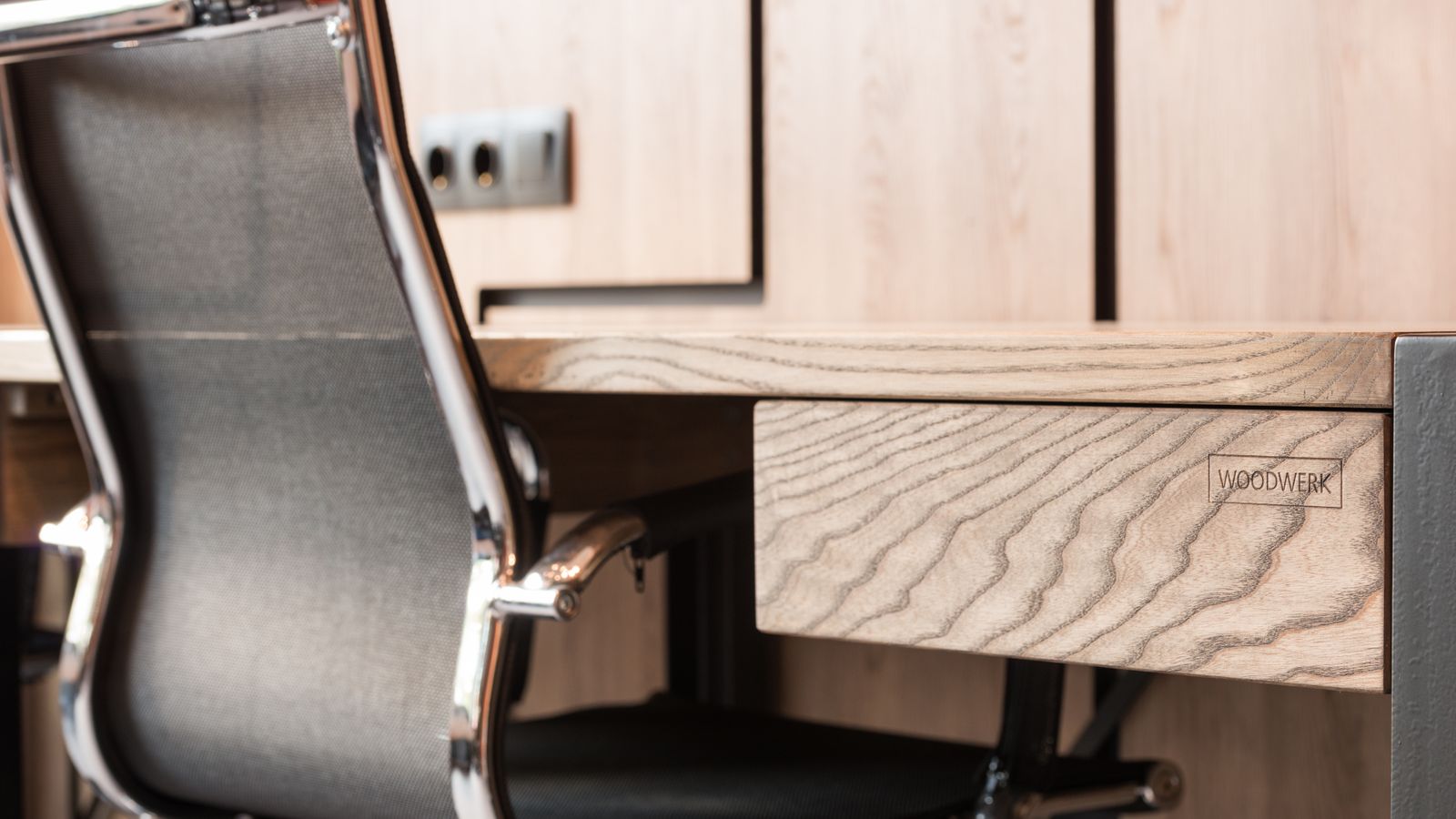 Person wiping down and caring for a solid wood desk surface with a cloth