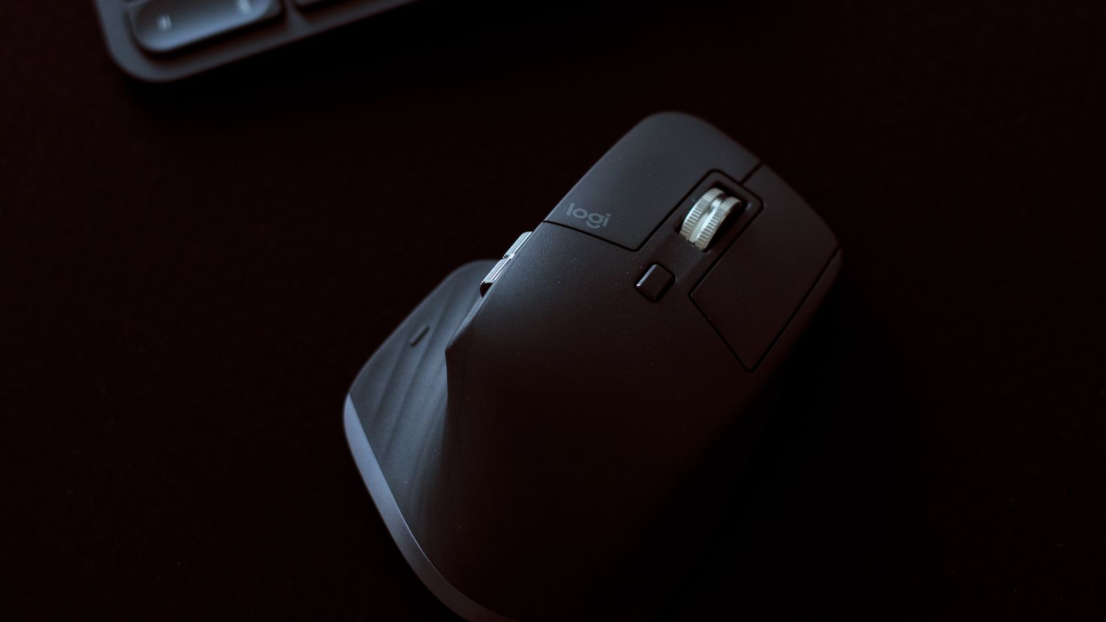 Close-up of a hand operating a thumb-controlled trackball mouse