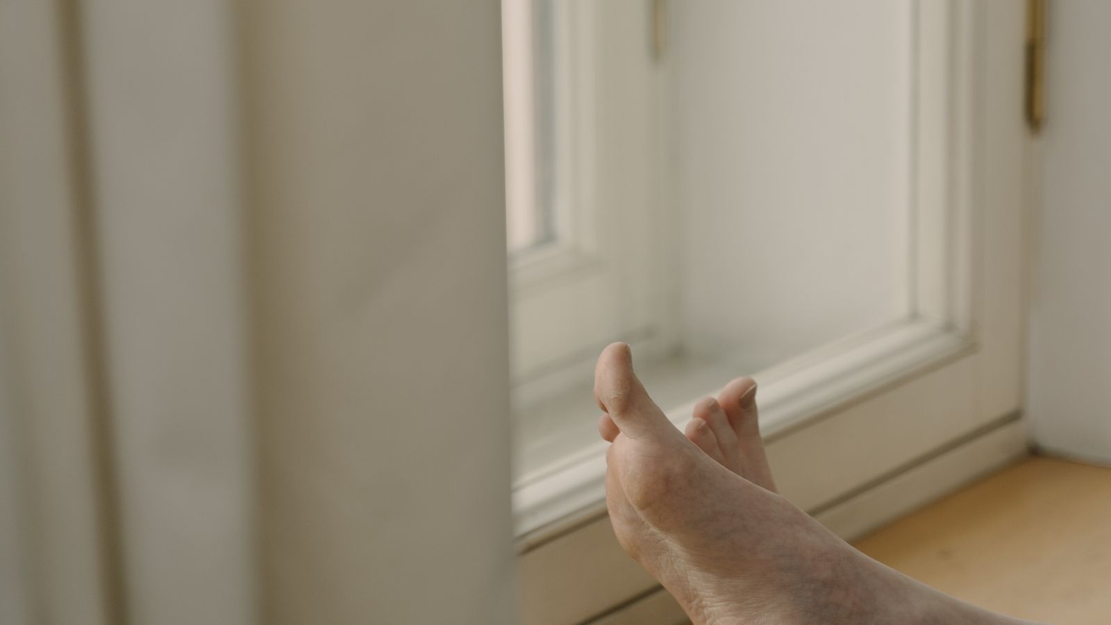 Close-up of hand tightening a bolt on a footrest base to fix wobbling