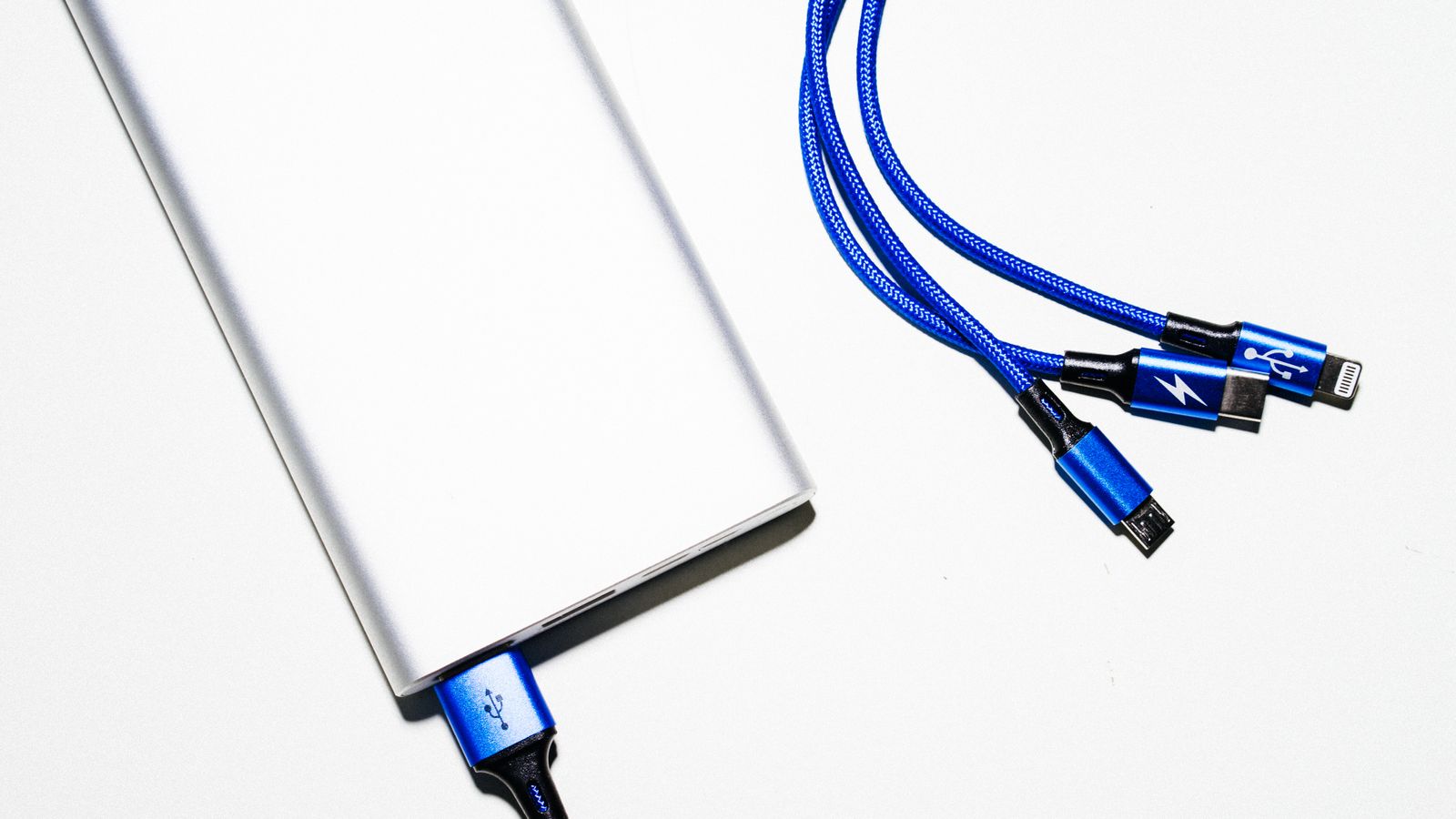 Person checking a portable charger power bank and cable on a desk
