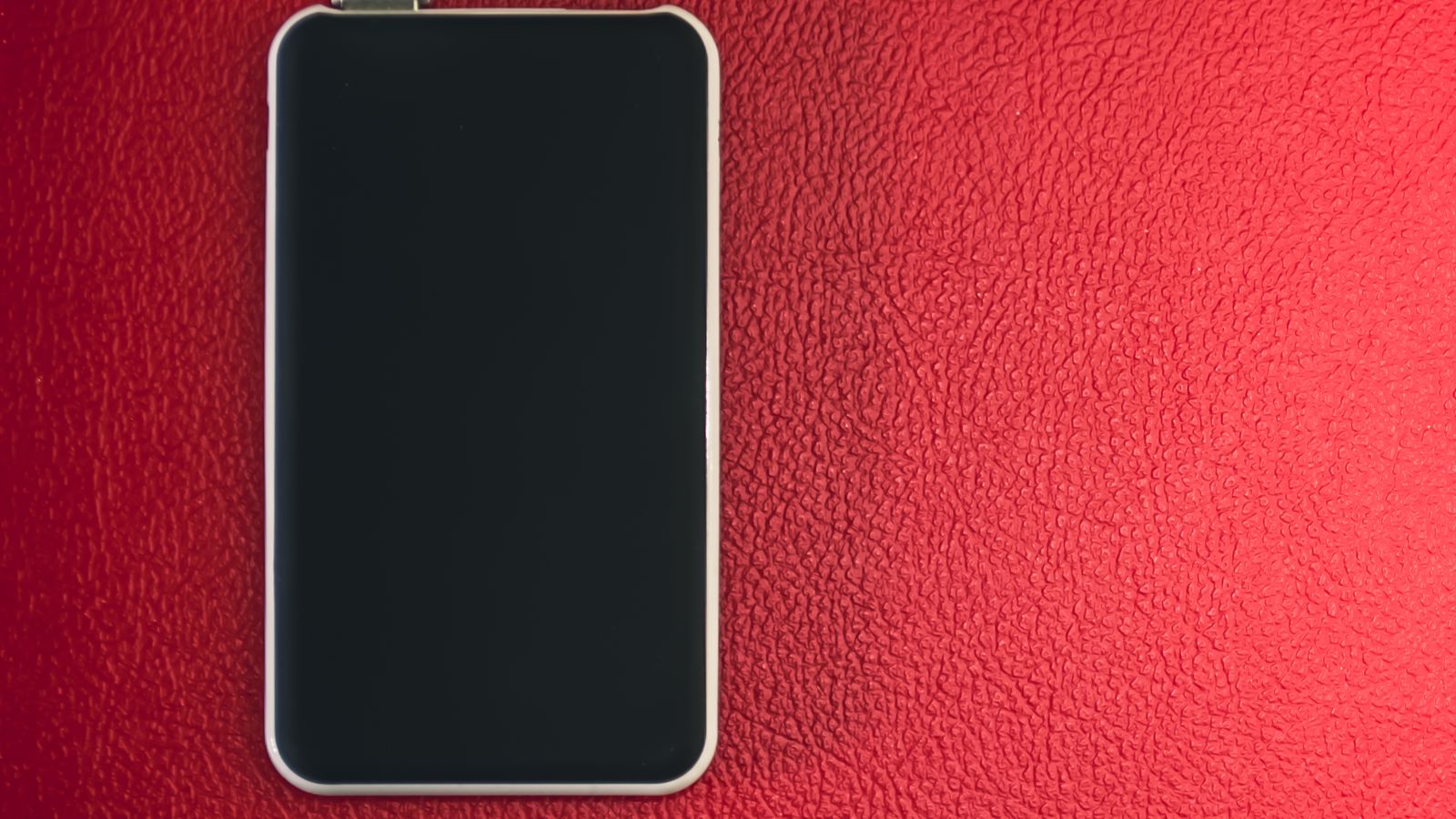 Close-up of a USB-C port on a power bank being cleaned with a small brush