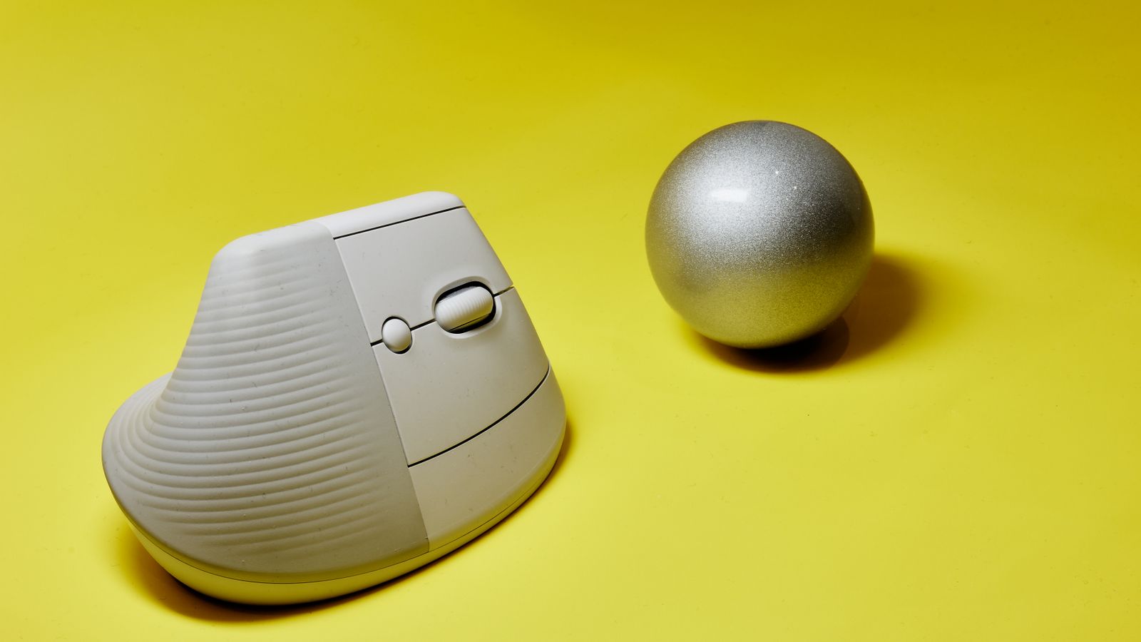 Close-up of a thumb-operated trackball mouse on a desk being cleaned