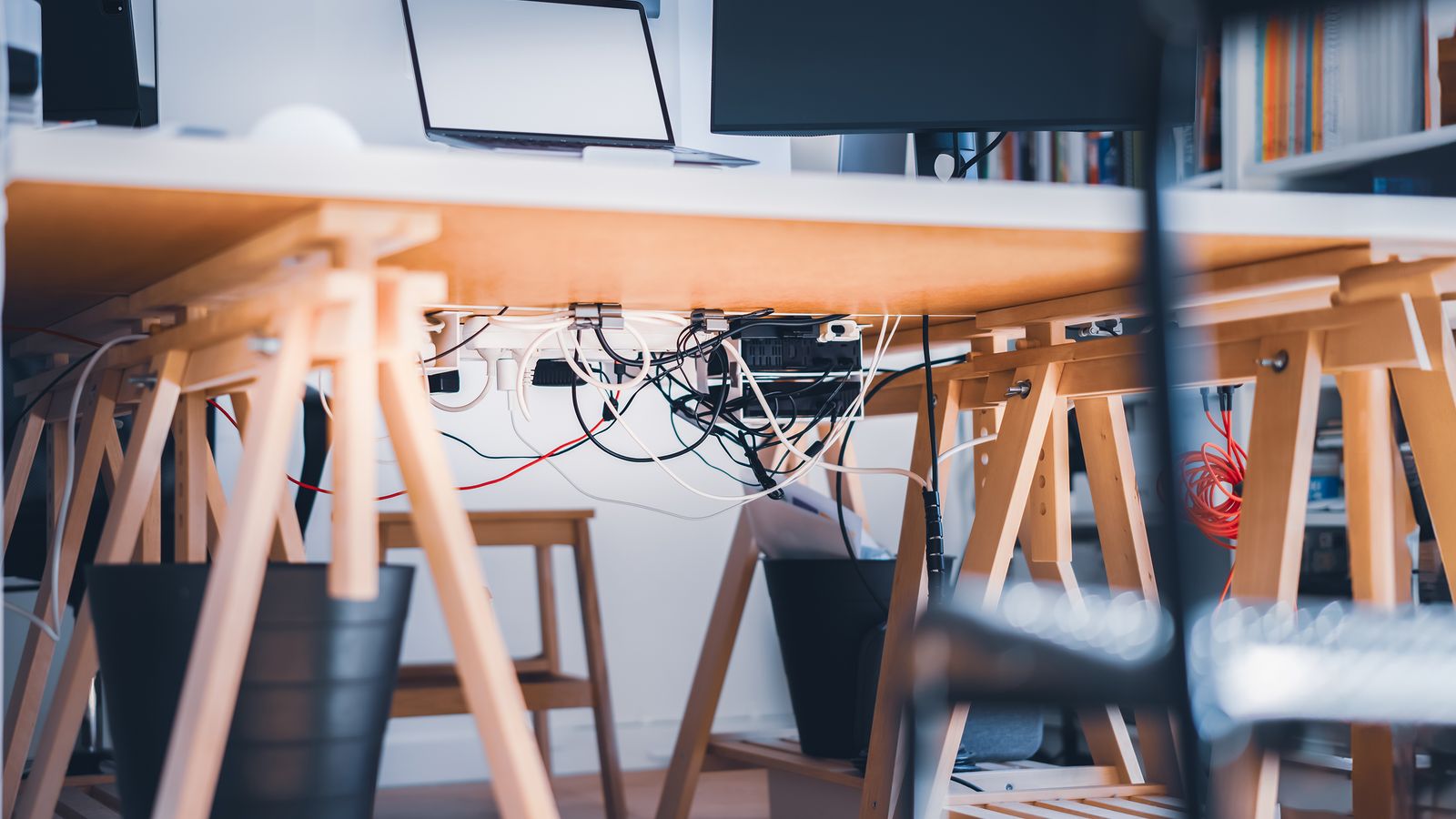 Organized desk setup with cable management tray and charging dock under a monitor